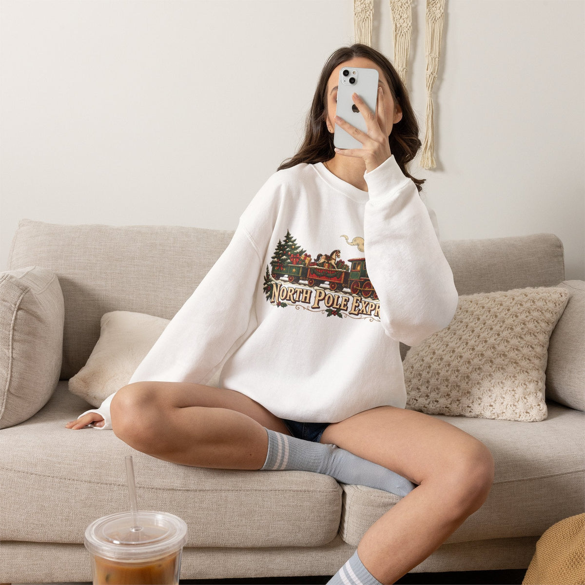 Wicked Thread Society white crewneck sweatshirt with a vintage North Pole Express train graphic worn by a woman