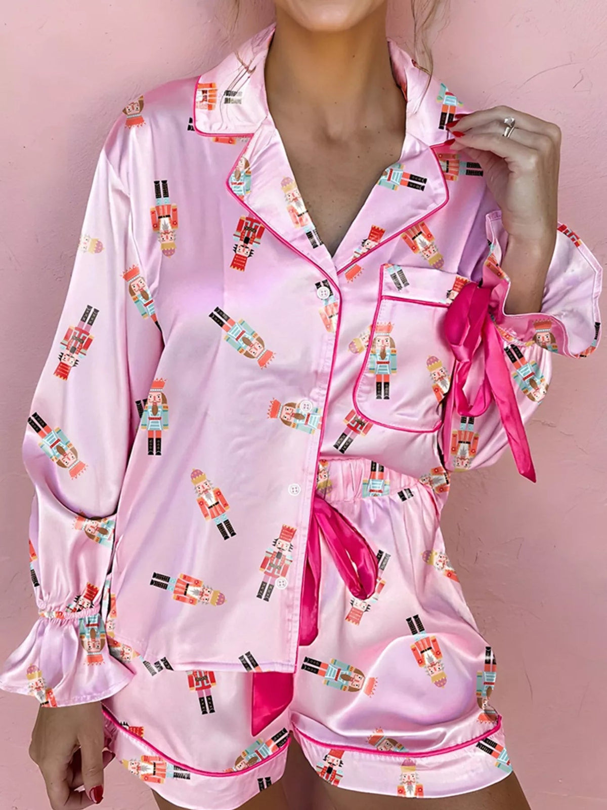 Wicked Thread Society pink pajama set with nutcracker print, button-down top, contrast trim, and tied sleeve details.