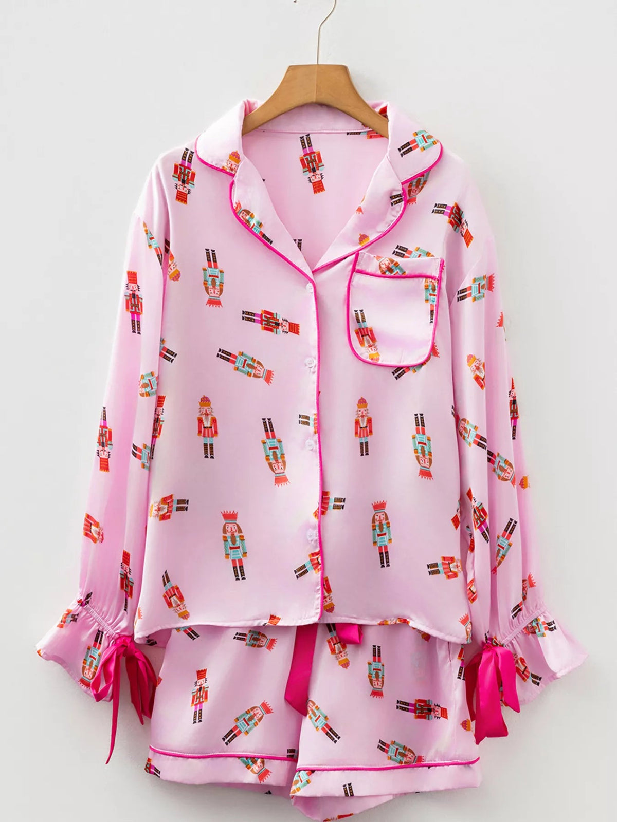 Wicked Thread Society pink pajama set with nutcracker print, button-down top, and shorts with ribbon tie details.