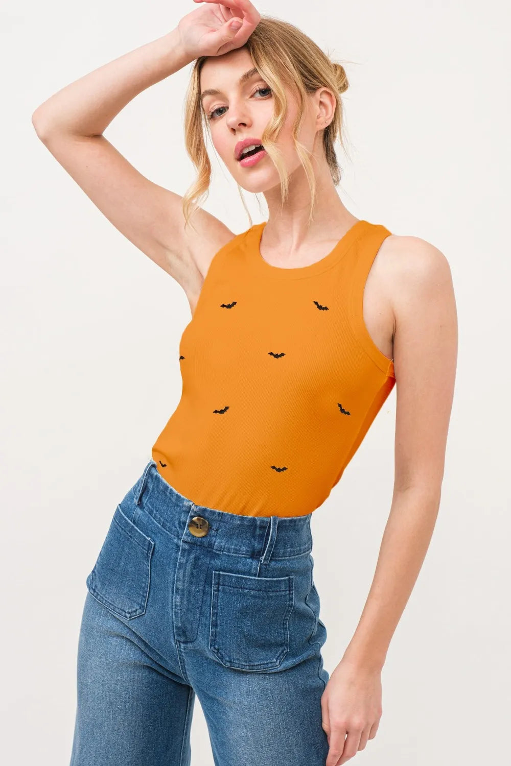 Wicked Thread Society orange ribbed tank top with small black bat embroidery worn by a model with blue jeans