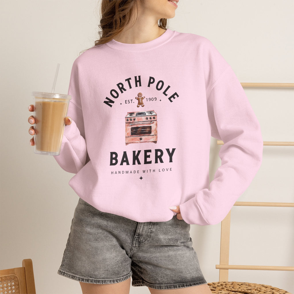 Wicked Thread Society light pink crewneck sweatshirt with a North Pole Bakery oven and gingerbread man graphic