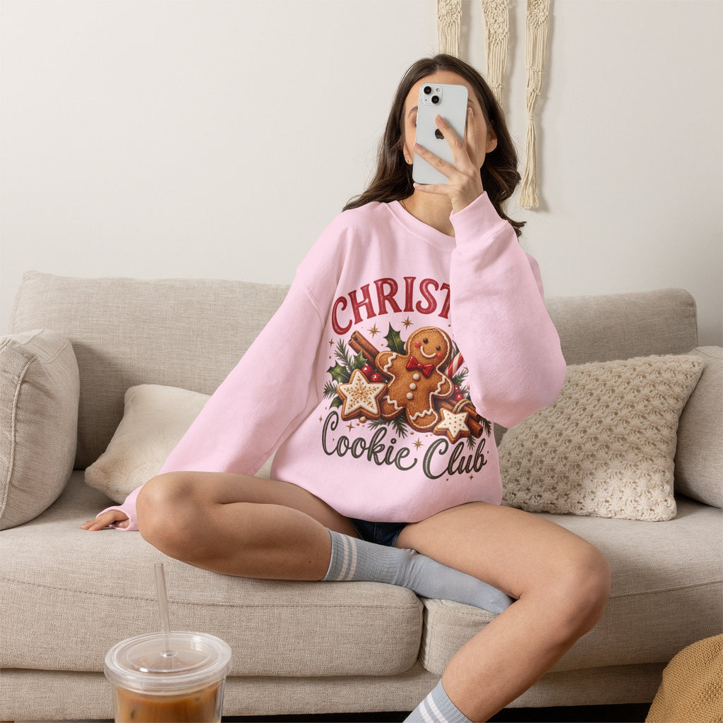 Wicked Thread Society light pink crewneck sweatshirt with a gingerbread man Christmas graphic, worn by a woman.