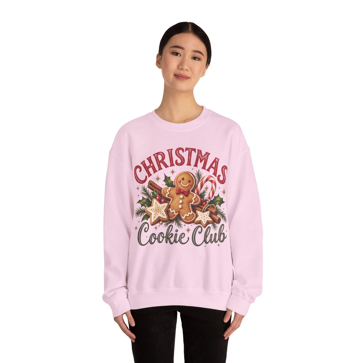 A model wearing a light pink Wicked Thread Society crewneck sweatshirt with a gingerbread man Christmas graphic.