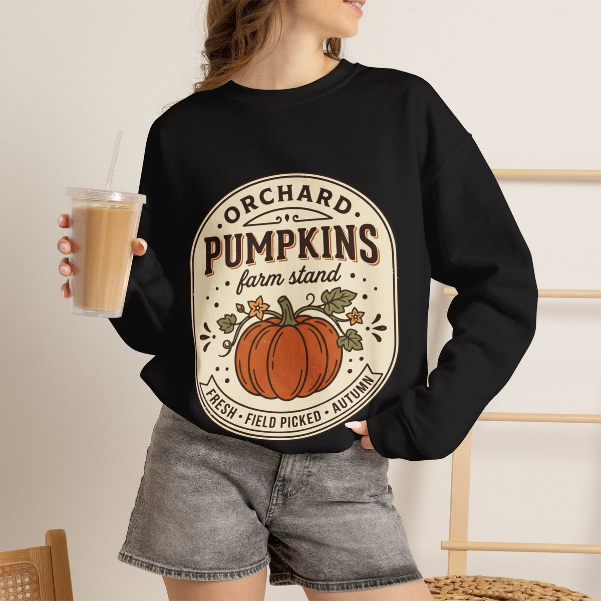 Wicked Thread Society black crewneck sweatshirt with a vintage pumpkin farmstand graphic, worn with grey denim shorts.