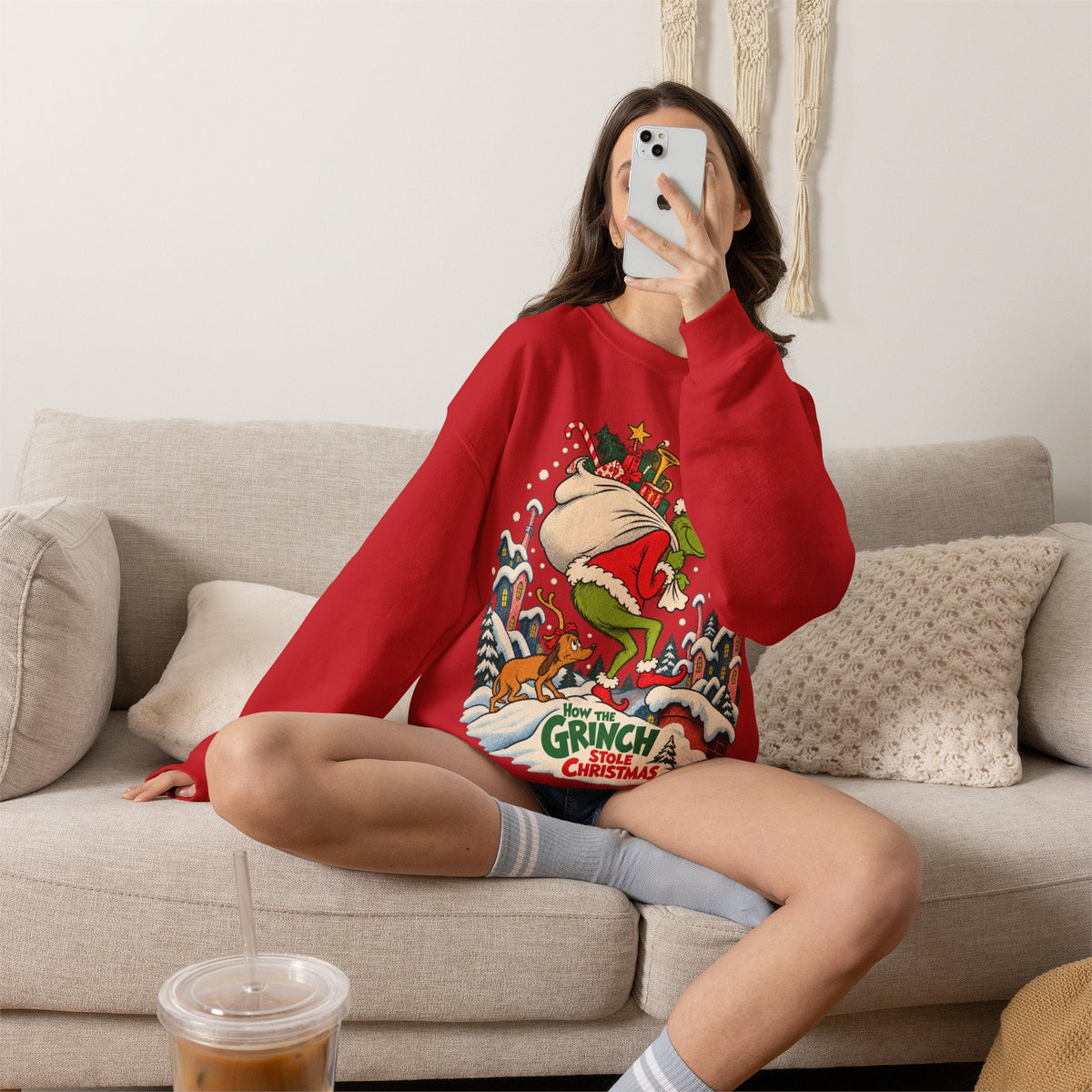 Wicked Thread Society red crewneck sweatshirt featuring a vintage Grinch Christmas illustration worn by a woman.