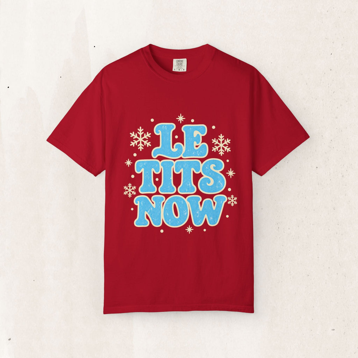 Wicked Thread Society red holiday graphic tee with distressed blue Le Tits Now text and white snowflake accents