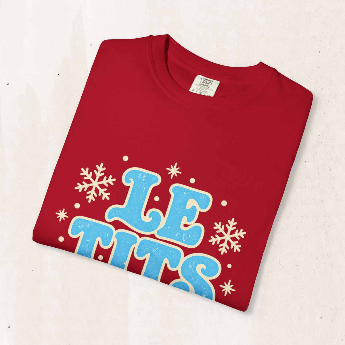 Wicked Thread Society red graphic tee with distressed blue Le Tits Now text and white snowflake accents