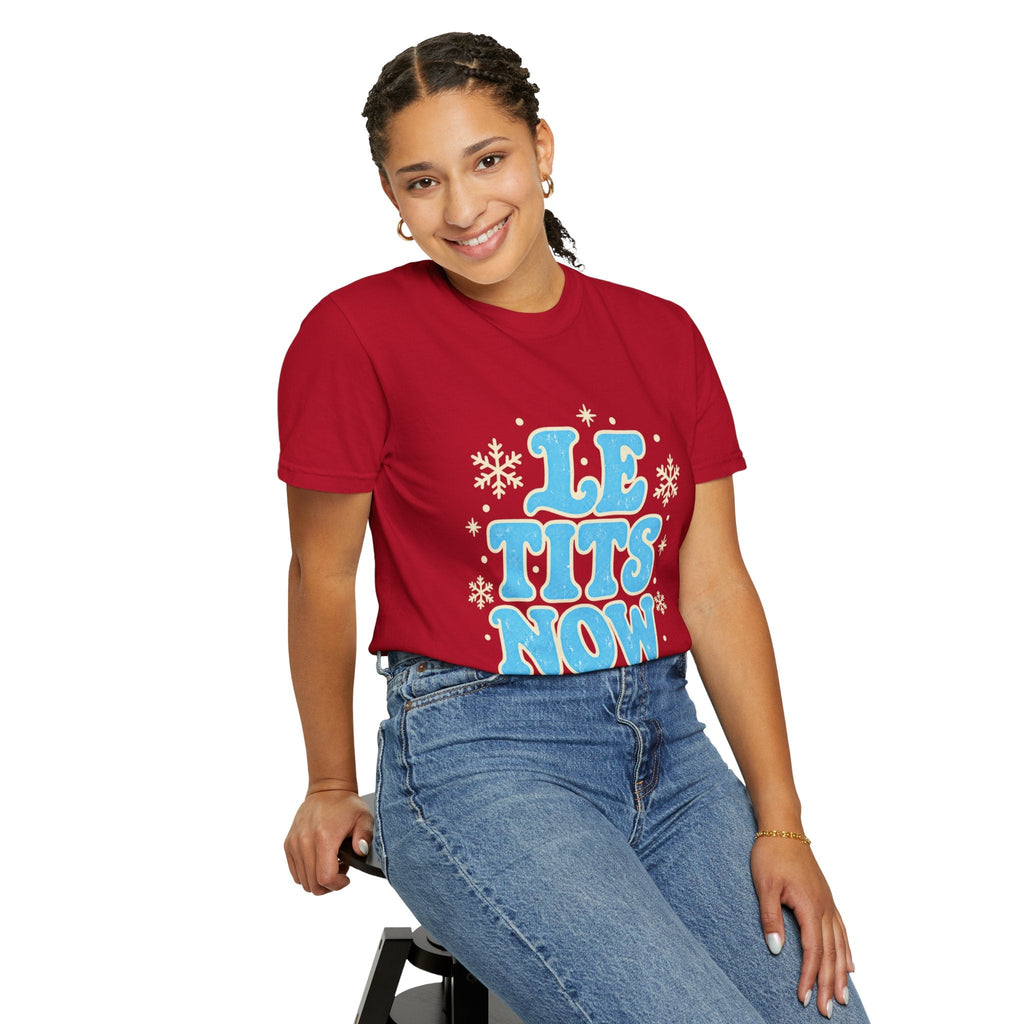 Wicked Thread Society red graphic tee with Le Tits Now text and snowflakes worn by a smiling woman in blue jeans.