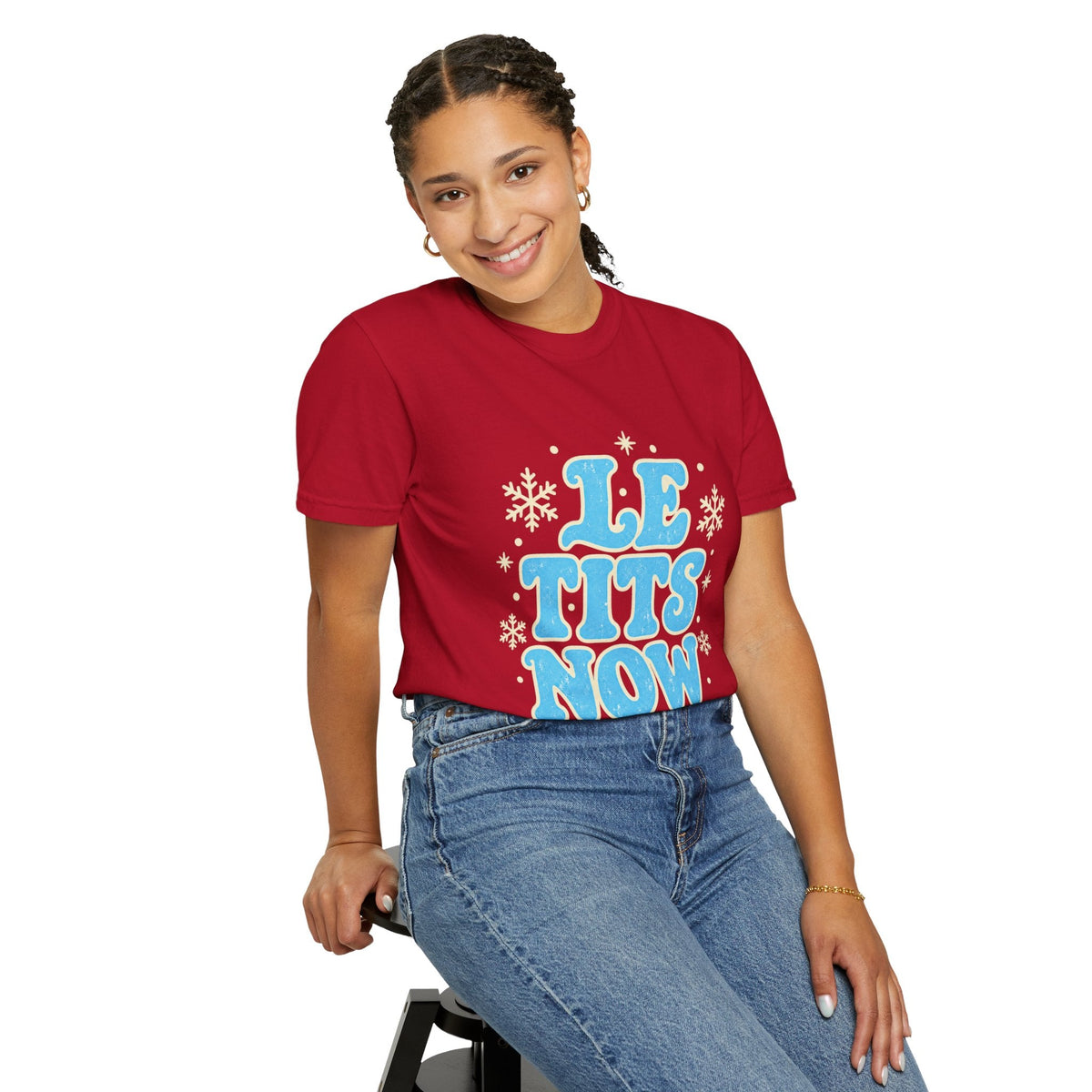 Wicked Thread Society red graphic tee with Le Tits Now text and snowflakes worn by a smiling woman in blue jeans.