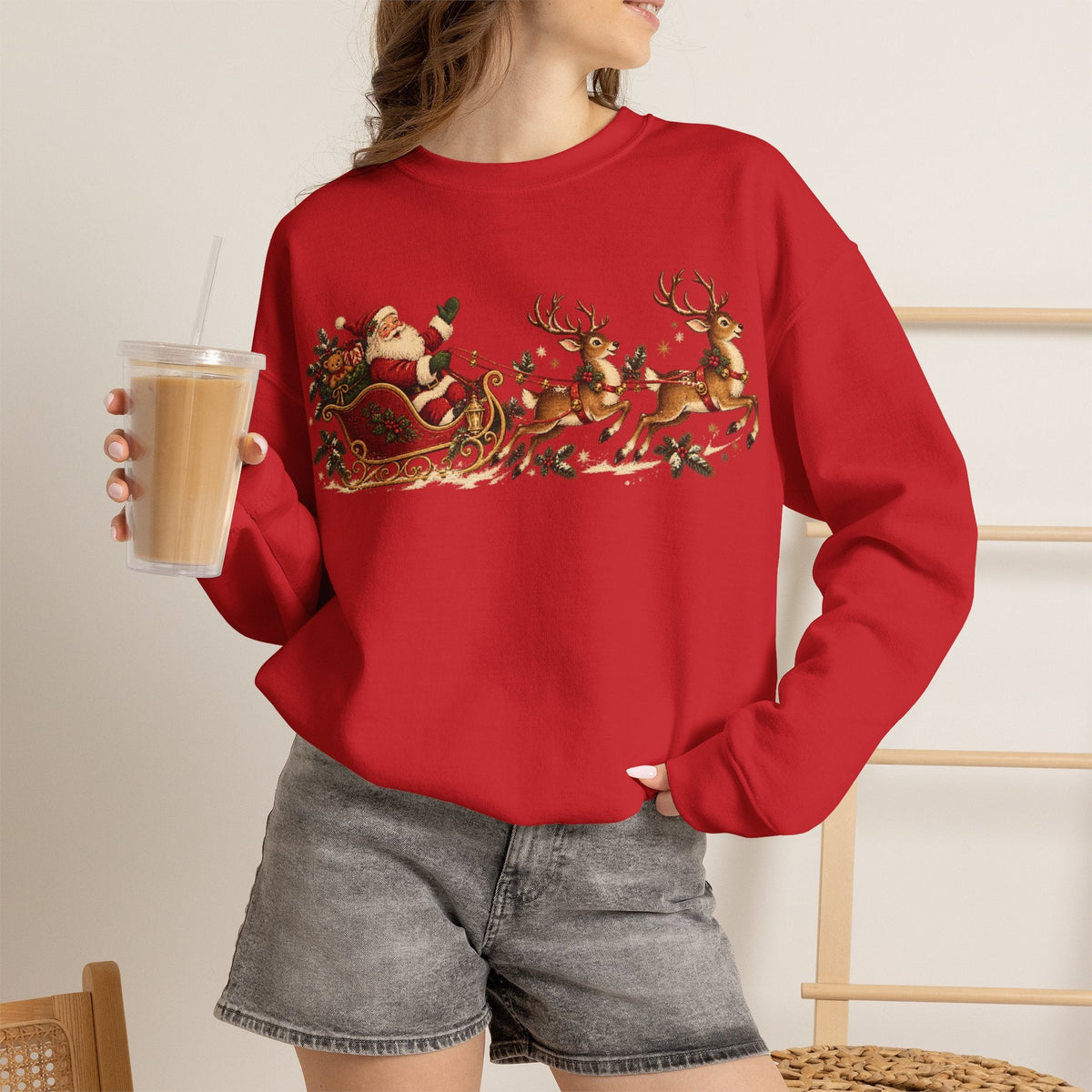 Wicked Thread Society red crewneck sweatshirt featuring a vintage Santa sleigh and reindeer print, worn by a woman.