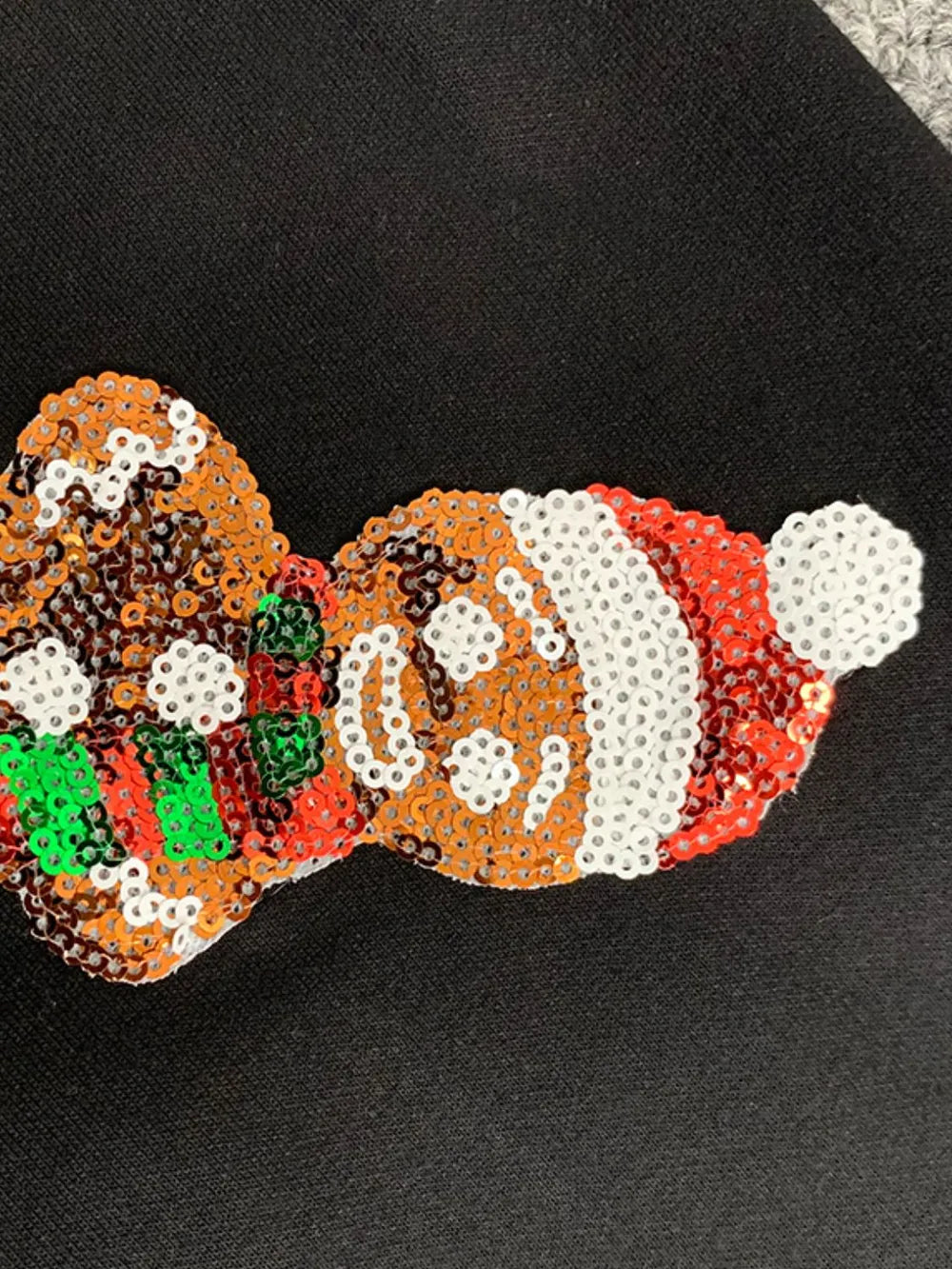 Wicked Thread Society black sweatshirt featuring a festive gingerbread man applique made of colorful sequins