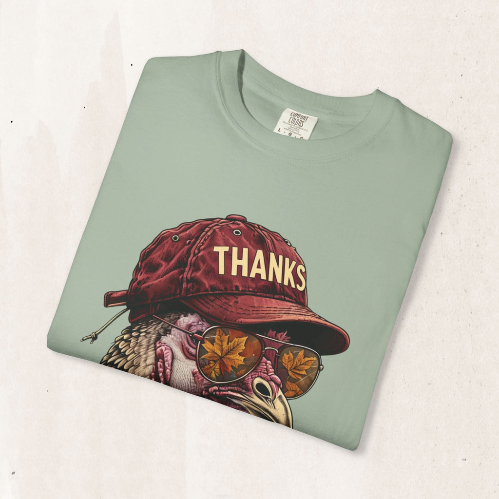 Wicked Thread Society sage green t-shirt featuring a turkey wearing a red baseball cap and sunglasses with leaf print