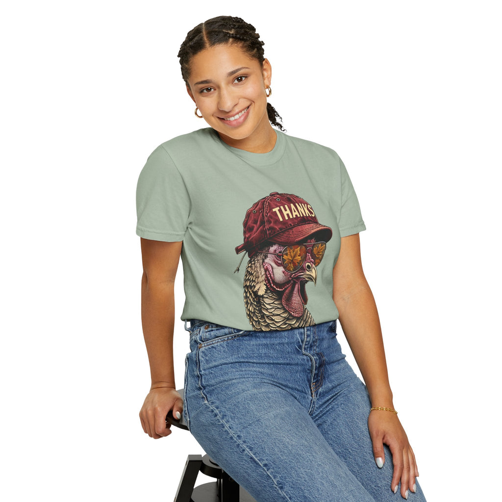 Woman wearing a sage green Wicked Thread Society Thanksgiving graphic t-shirt featuring a turkey in a cap and glasses.