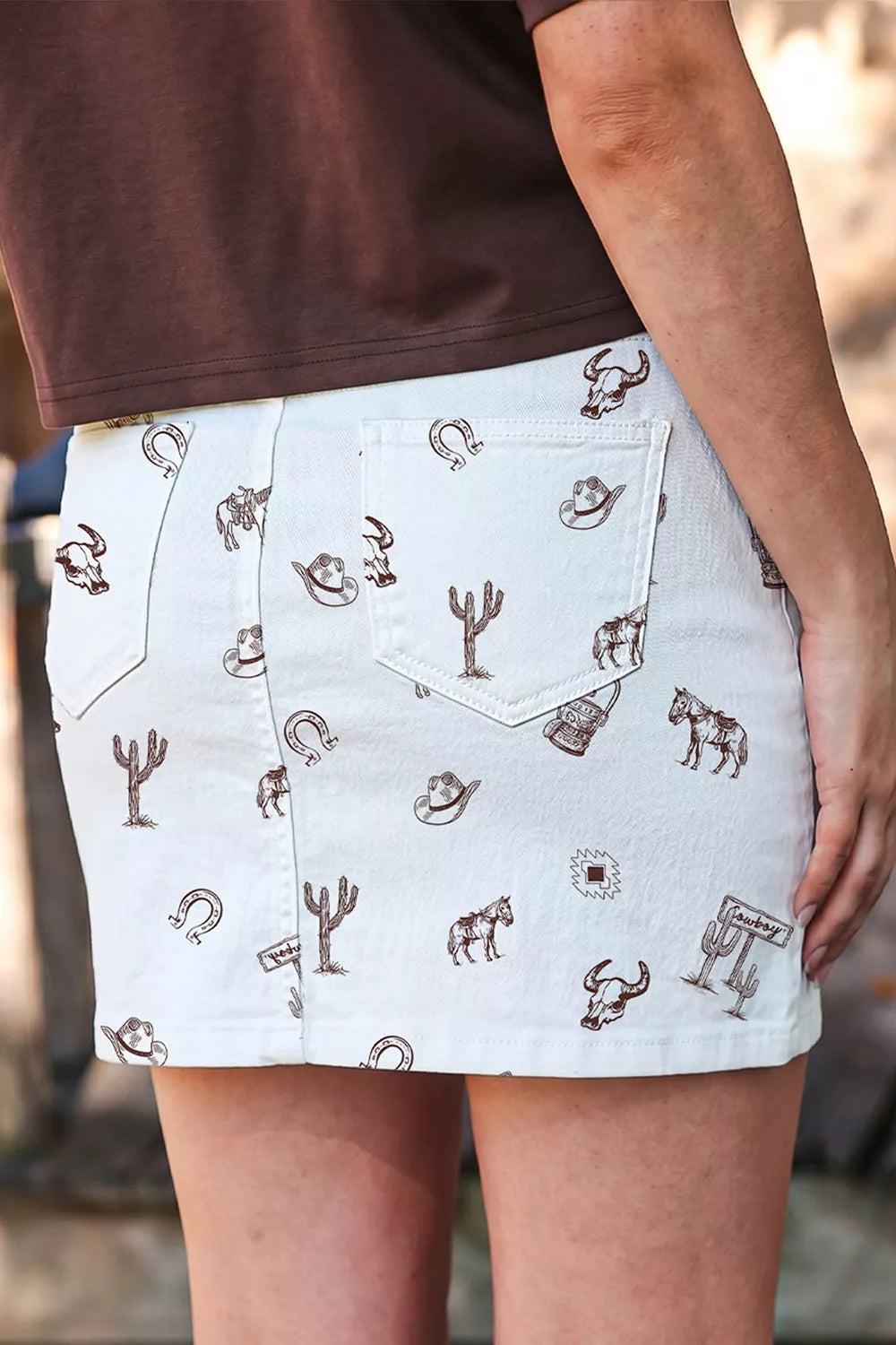 Wicked Thread Society white denim skirt with brown western print featuring cacti, horses, and bull skulls.